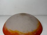 a large orange and white bowl sitting on a white surface