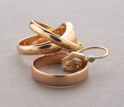 two gold rings with a diamond in them on a table