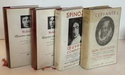 Trois livres sont alignés sur une table devant un mur blanc.