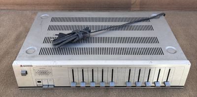 un gros plan d'un appareil électronique argenté posé sur une surface marron