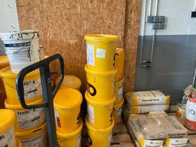 de nombreux seaux jaunes posés sur une palette dans une pièce