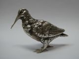 figurine d'oiseau en argent avec un long bec et de longues pattes