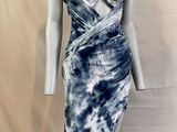 Le mannequin porte une robe bleue et blanche sur son socle.