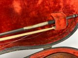a violin case with a violin and a violin stick in it