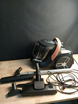 un aspirateur posé sur une table à côté d'autres objets