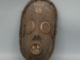 a wooden mask that has a face on it