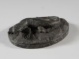 une petite statue représentant un lézard, posée sur une assiette