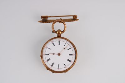 une petite montre de poche en or suspendue à une broche en or