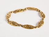 a close up of a gold bracelet on a white surface