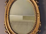 an ornate gold framed mirror on a wall in a room