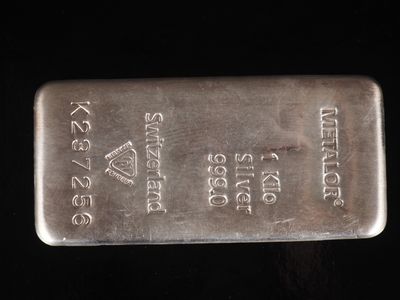 un gros plan d'un lingot d'argent posé sur une surface noire