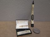 a small box with a pen and a small coin on a table