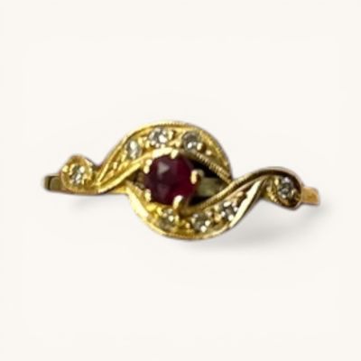 an image of a gold ring with a red stone surrounded by diamonds