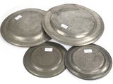 four silver plates with labels on them on a white surface