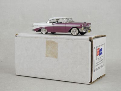 une petite voiture posée sur une boîte, sur une surface blanche