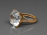 un gros plan d'une bague en or sertie d'un cristal transparent