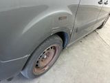 a grey van with a flat tire parked in a garage