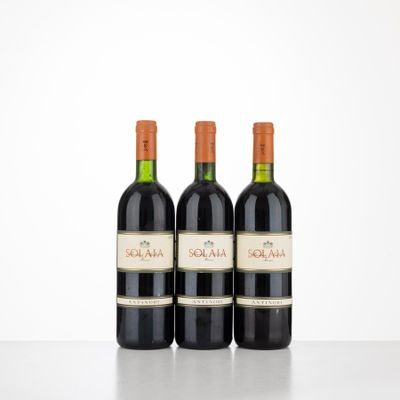 trois bouteilles de vin rouge sont posées sur une table