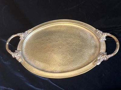 a gold tray with handles and handles on a black background