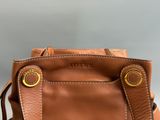 un gros plan d'un sac à main marron posé sur une table