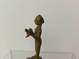 a small statue of a man holding a bird on a glass table