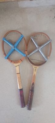 deux raquettes de tennis posées par terre l'une à côté de l'autre