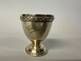 an antique silver cup with writing on it sitting on a table