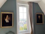 deux tableaux accrochés au mur d'une chambre, près d'une fenêtre