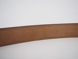 a close up of a brown leather belt on a white surface