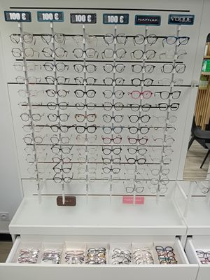 un présentoir de lunettes dans un magasin, sur lequel sont disposées de nombreuses paires de lunettes
