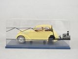 une petite voiture jaune dans une vitrine transparente posée sur une table