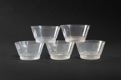 six clear glass cups sitting on top of a black surface