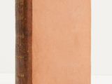 an old book sitting on top of a table next to a white wall