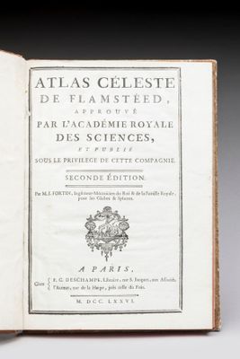 un livre ouvert posé sur une table à côté d'une tasse de café