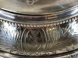 a silver plate with a lid that has a design on it