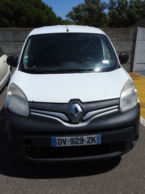 une camionnette blanche garée sur un parking à côté d'une voiture blanche