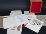 an image of a pile of papers and a red box on a table