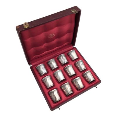six silver cups in a red case on a white background