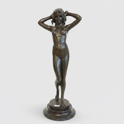 a bronze statue of a woman with her hands on her head