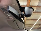 a rear view mirror of a car with a cell phone attached to it
