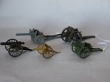 four toy guns and a cannon on a white surface