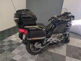 a black motorcycle parked in a room with a checkered floor