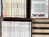 Des cartons remplis de livres sont empilés les uns sur les autres par terre