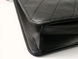a close up of a black chanel bag on a white background