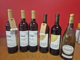plusieurs bouteilles de vin sont alignées sur une table en bois