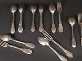 many forks and spoons laid out on a table