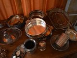 a wooden table with a bunch of silver dishes on it