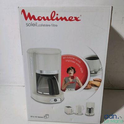 La boîte de la cafetière est ouverte sur la table.