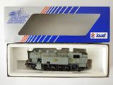 une boîte contenant un petit train, posée sur une surface blanche