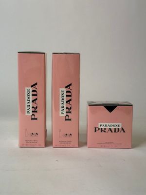 three boxes of prada perfume on a white surface